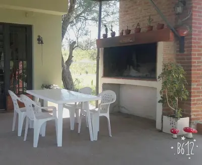 a white table and chairs in front of a fireplace at Mirador de estrellas in Villa Rumipal