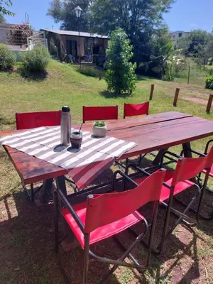 a wooden table with red chairs around it at Mirador de estrellas in Villa Rumipal