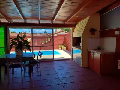 a kitchen and dining room with a table and a pool at Departamento en Barrio Santa Rita in Villa Carlos Paz