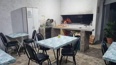 a restaurant with tables and chairs and a stove at El Jorgito in Villa Carlos Paz