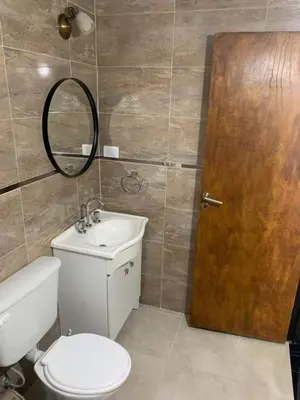 a bathroom with a toilet and a sink and a mirror at El Jorgito in Villa Carlos Paz