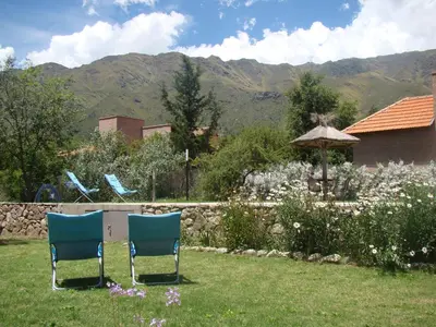 two chairs and an umbrella in a garden at Rumbo 020 Apart in Merlo