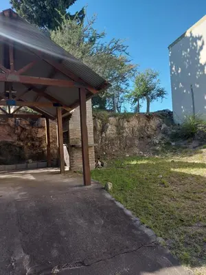 a building with a pavilion next to a grass field at Cabaña Aikén in Embalse