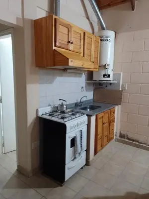 a kitchen with a stove and wooden cabinets at Cabaña Aikén in Embalse