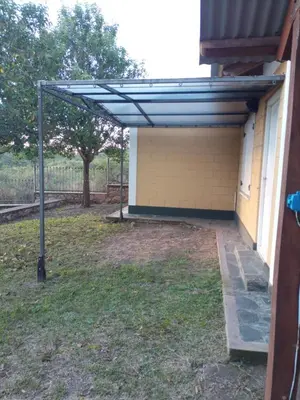 a pergola on the side of a building at Cabaña Aikén in Embalse