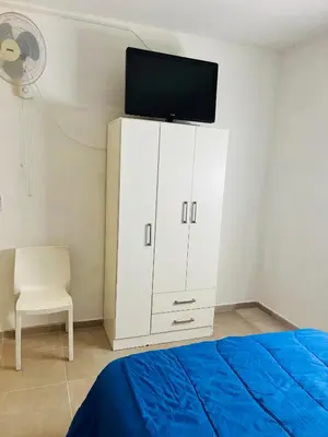 a bedroom with a bed and a cabinet with a tv on it at Departamentos Arroyo de Los Patos in Arroyo de Los Patos
