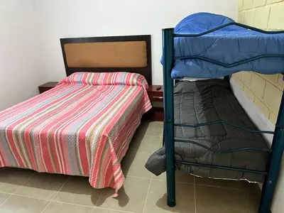 a bedroom with a bunk bed next to a bed gmaxwell gmaxwell gmaxwell gmaxwell at Departamentos Arroyo de Los Patos in Arroyo de Los Patos