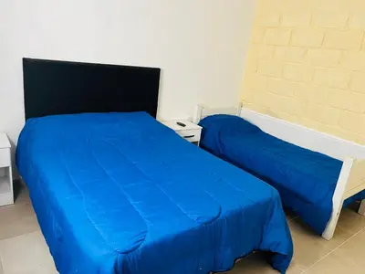 a bedroom with two beds with blue sheets at Departamentos Arroyo de Los Patos in Arroyo de Los Patos