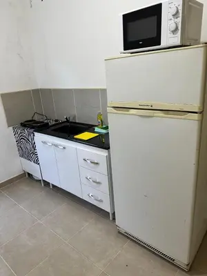 a kitchen with a microwave on top of a refrigerator at Departamentos Arroyo de Los Patos in Arroyo de Los Patos