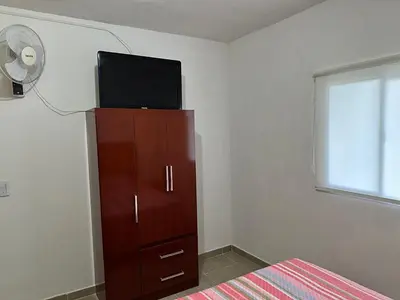 a bedroom with a tv on top of a dresser at Departamentos Arroyo de Los Patos in Arroyo de Los Patos
