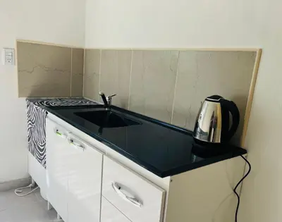 a kitchen with a black counter top and a sink at Departamentos Arroyo de Los Patos in Arroyo de Los Patos