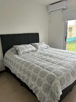 a bedroom with a bed with a comforter and a window at Puerto del Águila home in La Estancia