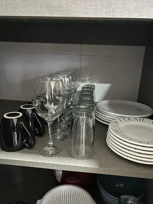 a row of wine glasses and plates on a shelf at Puerto del Águila home in La Estancia