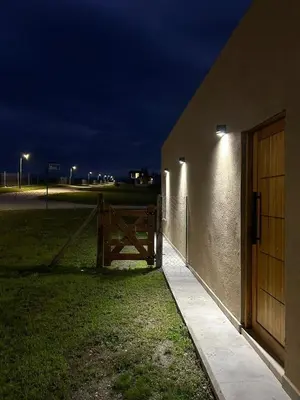 a fence next to a building with a wooden door at Puerto del Águila home in La Estancia