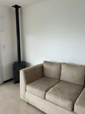 a brown couch in a living room with a lamp at Puerto del Águila home in La Estancia