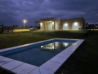 a house with a swimming pool in the yard at night at Puerto del Águila home in La Estancia