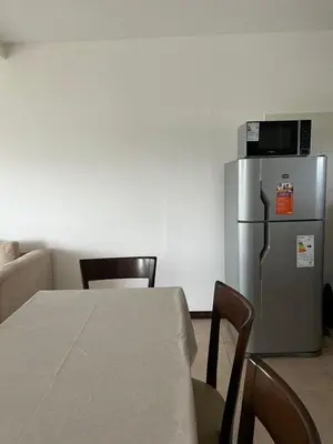 a kitchen with a table and a refrigerator at Puerto del Águila home in La Estancia