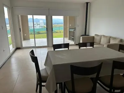 a living room with a table and chairs and a couch at Puerto del Águila home in La Estancia