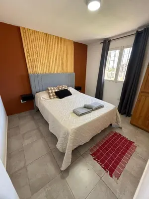 a bedroom with a large bed with two pillows on it at Casa con pileta a 2 cuadras del río in San Antonio de Arredondo