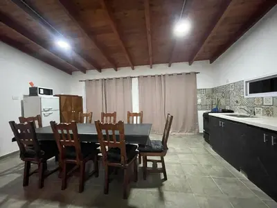 a kitchen and dining room with a table and chairs at Casa con pileta a 2 cuadras del río in San Antonio de Arredondo