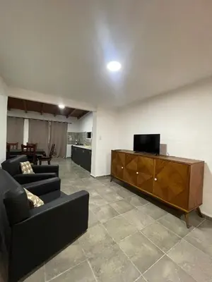 a living room with two couches and a television at Casa con pileta a 2 cuadras del río in San Antonio de Arredondo