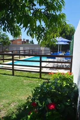 a swimming pool with a fence and flowers in a yard at Secret Garden in San Antonio de Arredondo