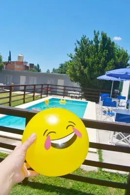 a person holding a smiley face emoticon in front of a pool at Secret Garden in San Antonio de Arredondo
