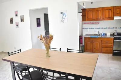 a dining room table with a vase of flowers on it at Secret Garden in San Antonio de Arredondo