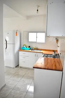 a kitchen with white appliances and a white refrigerator at Secret Garden in San Antonio de Arredondo