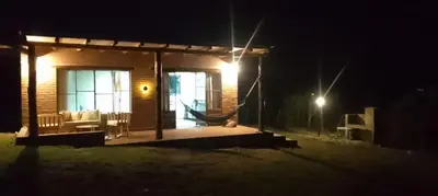 a small house with a porch at night at Balcón Natural in Los Hornillos