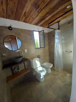 a bathroom with a toilet and a sink and a mirror at Balcón Natural in Los Hornillos
