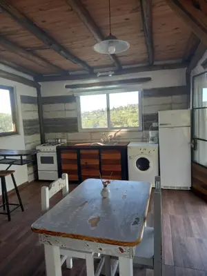 a kitchen with a table and a stove and a refrigerator at Balcón Natural in Los Hornillos