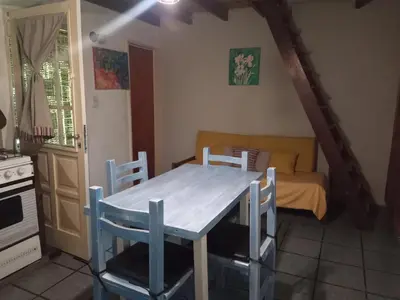 a kitchen with a table and chairs and a couch at La Rinconada Nono in Nono