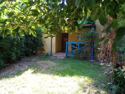 a house with a blue gate under a tree at La Rinconada Nono in Nono