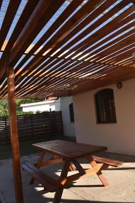a wooden picnic table under a wooden pergola at Oasis casa de descanso in Villa Carlos Paz