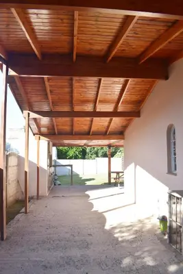 a wooden pergola on the side of a building at Oasis casa de descanso in Villa Carlos Paz