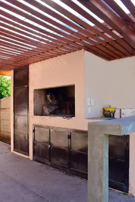 a building with two metal garage doors with a window at Oasis casa de descanso in Villa Carlos Paz