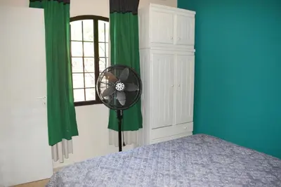 a bedroom with a fan next to a window at Oasis casa de descanso in Villa Carlos Paz