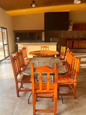 a dining room with a table and wooden chairs at Apart La Ideal in Villa Cura Brochero
