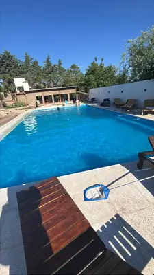 a large swimming pool with blue water at Apart La Ideal in Villa Cura Brochero