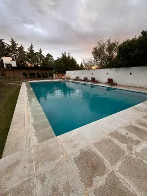 a swimming pool with blue water in a yard at Apart La Ideal in Villa Cura Brochero