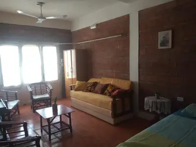 a living room with a couch and a brick wall at CHE Camilo in Tanti