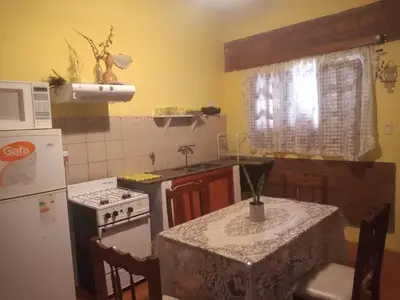 a kitchen with a table and a stove and a refrigerator at CHE Camilo in Tanti