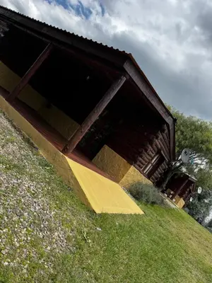 a building on top of a grassy hill at Amanecerenunsueñoyacanto in El Durazno