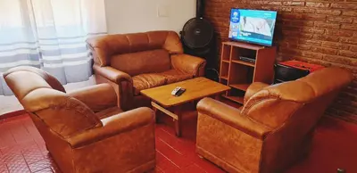 a living room with leather chairs and a television at Hermosa casa en Carlos paz in Villa Carlos Paz