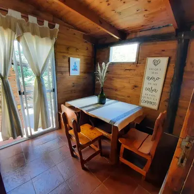 a dining room with a table and chairs in a cabin at La luisa segunda in Villa Parque Siquiman