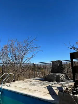 a swimming pool with a fence and blue sky at La luisa segunda in Villa Parque Siquiman