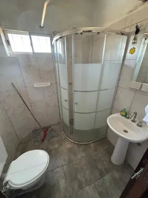 a bathroom with a shower and a toilet and a sink at La luisa segunda in Villa Parque Siquiman