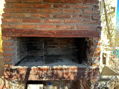 an outdoor brick oven with a chair in it at La luisa segunda in Villa Parque Siquiman