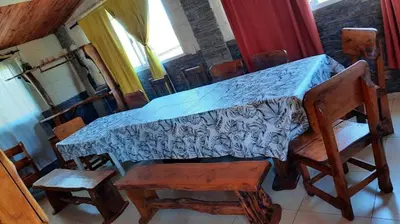 a room with a table with chairs and a bed at La luisa segunda in Villa Parque Siquiman